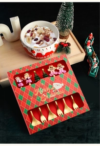 Detailed view of six golden stainless steel forks with colorful Christmas themed handle toppers