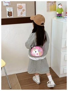 Pink unicorn crossbody bag for girls showing glitter horn and mane in home setting