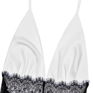 Detail des weißen Satinkleids mit feiner schwarzer Spitze und tiefem V-Ausschnitt-Design