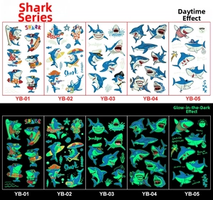 Glow-in-the-dark shark cartoon tattoo stickers for kids featuring pirate and surfing designs