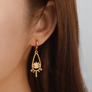 18K gold plated stainless steel eye drop earrings with pearl detail on model