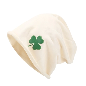 Détail du bonnet en maille crème avec imprimé trèfle vert et bord roulé souple