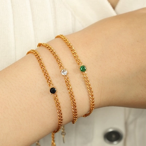 Dreiteiliges Set eleganter goldener Titanstahl-Armbänder mit schwarz-weiß-grünen Steinen
