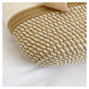 Macro shot of the beige and white woven texture and side tab detail on this tote bag