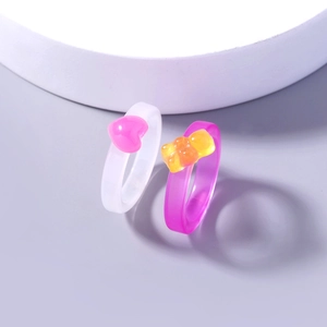 Close-up of cute resin rings with pink heart and purple gummy bear designs