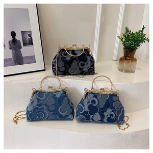 Detail of denim kiss-lock handbags with cloud patterns and gold chain straps