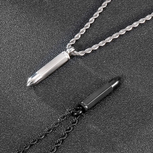 Detailed close-up of bullet pendant necklaces in silver and black with twisted chains