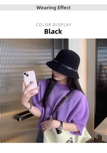 Dettaglio di un cappello a secchiello in maglia nera con cinturino in pelle indossato