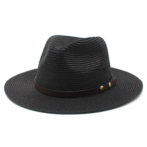 Detail of a black woven straw fedora hat with a brown leather band and metal studs