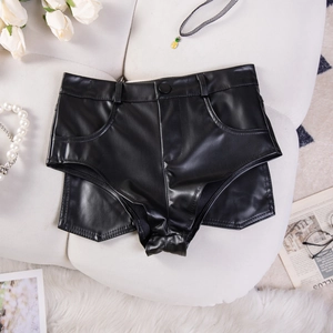 Detailaufnahme flach liegender schwarzer Kunstleder-Shorts mit hoher Taille und Deko
