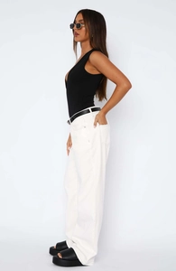 Side view of white straight-leg trousers with black belt and sleeveless bodysuit