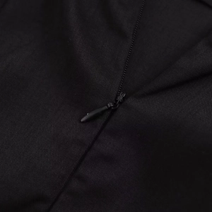 Gros plan détaillé sur la fermeture éclair cachée d'une mini robe noire sexy dos nu