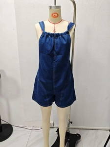 Detail of loose dark blue denim romper with adjustable straps and front pleated bodice