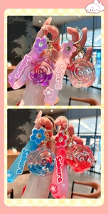 Close-up of Sakura themed rose flower keychains with liquid sand and silicone wristbands