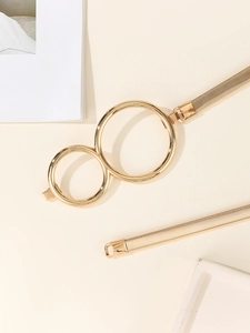 Close-up of golden elastic belt featuring a double ring metal buckle design