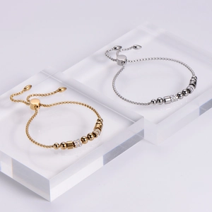 Detail of adjustable stainless steel bead bracelets in gold and silver with zircon accents