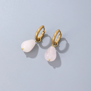 Detail of pink teardrop natural stone earrings with gold hoops on a blue background