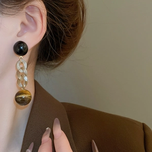 Detail view of retro long drop earrings with tiger eye resin beads and link chains