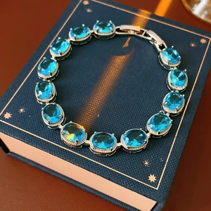 Detail of silver bracelet with oval blue cubic zirconia stones and secure clasp closure