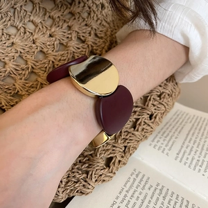 Chic gold-tone metal and deep red acrylic panels on a stretch bracelet with high polish finish