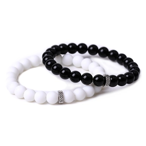 Detail of beaded couple bracelets with matte black agate and white turquoise stones