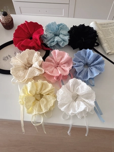 Flat lay of colorful lace scrunchies with long ribbons on a white table set