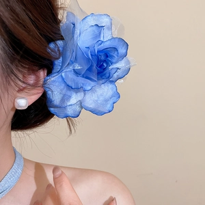 Détail d'une grande pince à cheveux fleur en maille bleue portée par un mannequin