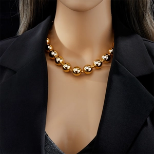 Fashionable gold beaded titanium steel necklace for women worn with a black blazer
