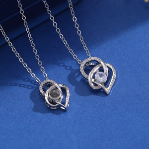 Detail of double heart necklaces featuring projection stone and romantic engraving