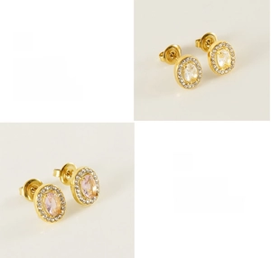 Detailed view of polished oval gold earrings with clear and pink zircon stones
