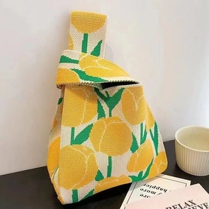 Detailed texture of knitted tulip knot bag featuring a large yellow flower pattern