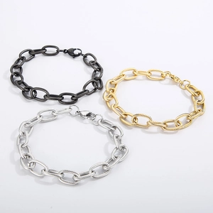 Detail of three twisted cable chain bracelets in black, gold, and silver stainless steel
