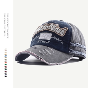 Detailed side view of navy and grey distressed denim baseball cap with embroidery