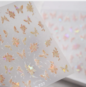 Macro detail of laser holographic butterfly and floral nail stickers with glitter finish