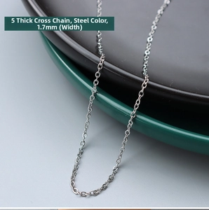 Macro detail of a 1.7mm wide steel color cross link chain on dark ceramic plates