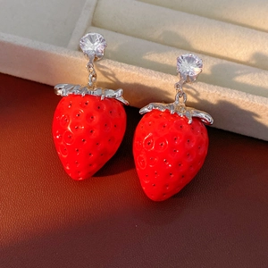 Dettaglio di orecchini a fragola rossa con foglia d'argento e zircone trasparente