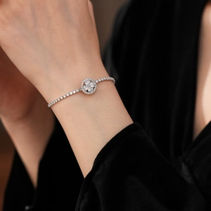 Close-up of a rotating clover bracelet with sparkling zircons on a model's wrist