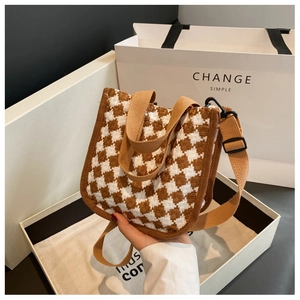 Detailed shot of brown houndstooth canvas handbag with adjustable fabric shoulder strap