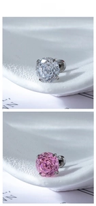 Macro detail of millennium rose zircon studs in pink and white with four-prong steel setting