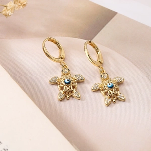 Detail of gold plated turtle earrings featuring blue evil eye and sparkling rhinestones