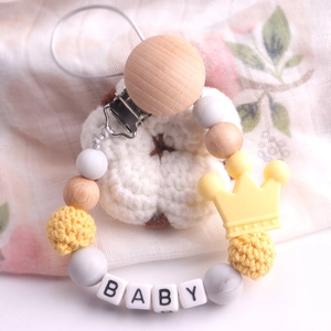 Detailed close-up of beechwood pacifier clip with yellow crown and silicone baby beads