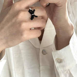 Close-up of a handmade black beaded ring featuring a unique balloon dog design