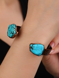 Detail view of vintage bronze cuff bracelet featuring irregular natural turquoise stones