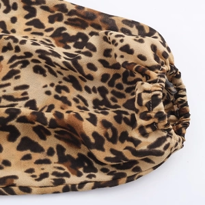 Dettaglio dei polsini elastici e della stampa leopardata su un abito in tessuto leggero