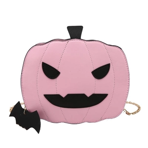 Close-up of pink pumpkin crossbody bag with black bat charm and gold chain strap detail
