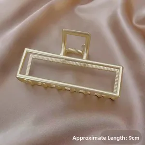 Detail of 9cm matte gold metal hair claw clip with micro 3D heart pattern on satin