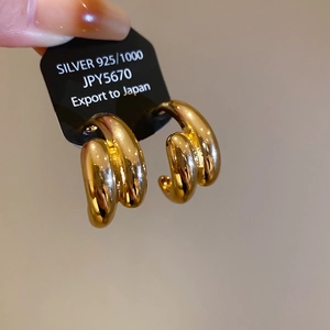 Close-up of triple-layered interwoven gold hoop earrings in S925 sterling silver