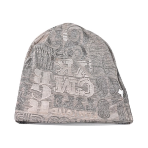 Detailaufnahme der Strickmütze mit Jacquard-Buchstaben und Webetikett in Grau-Braun