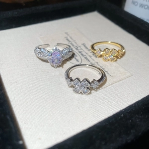 Detailed shot of zircon flower and clover rings with a purple oval gemstone crown set
