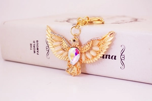 Close-up of golden eagle keychain with sparkling rhinestones and a colorful gemstone
